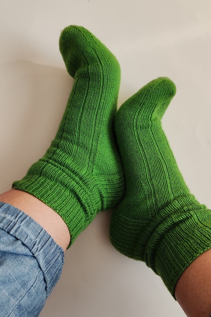 Green ribbed socks worn on feet, shown from the side